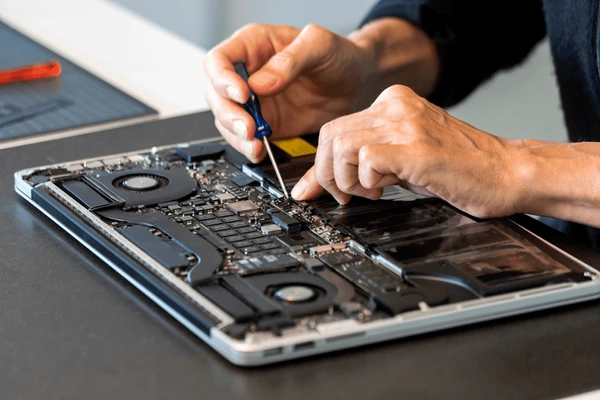 Technician working on a desktop computer with network cables